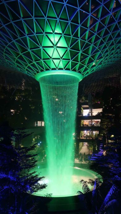 Singapore Changi-Airport Indoor Wasserfall: Im Flughafen Singapore befindet sich der weltgrößte künstliche Indore-Wasserfall. Das Wasser stürzt aus 40 Metern Höhe in die Tiefe. Das entspricht 7 Stockwerken des Flughafengebäudes